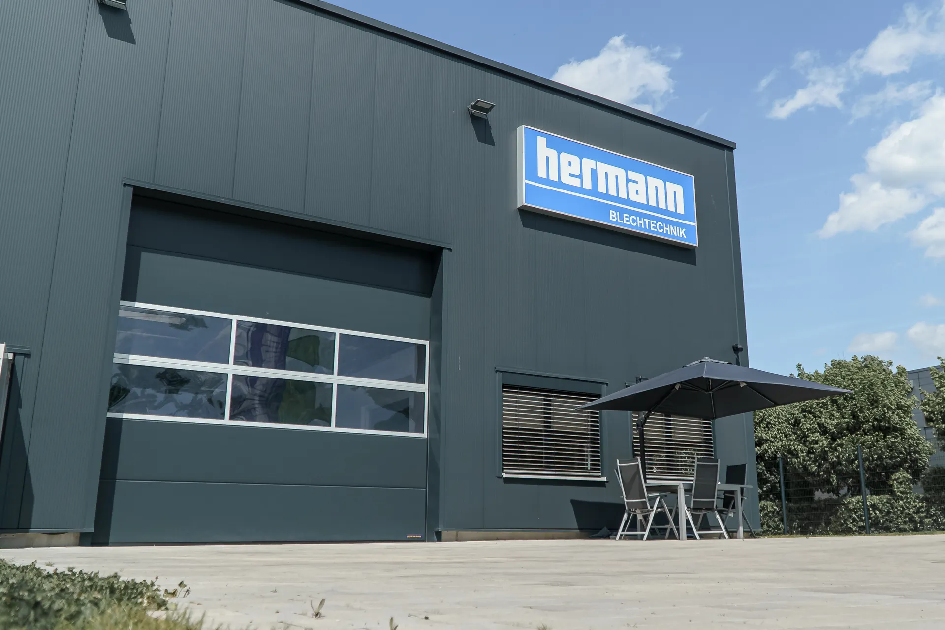 Firmengebäude von Hermann Blechtechnik mit Logo an der Fassade